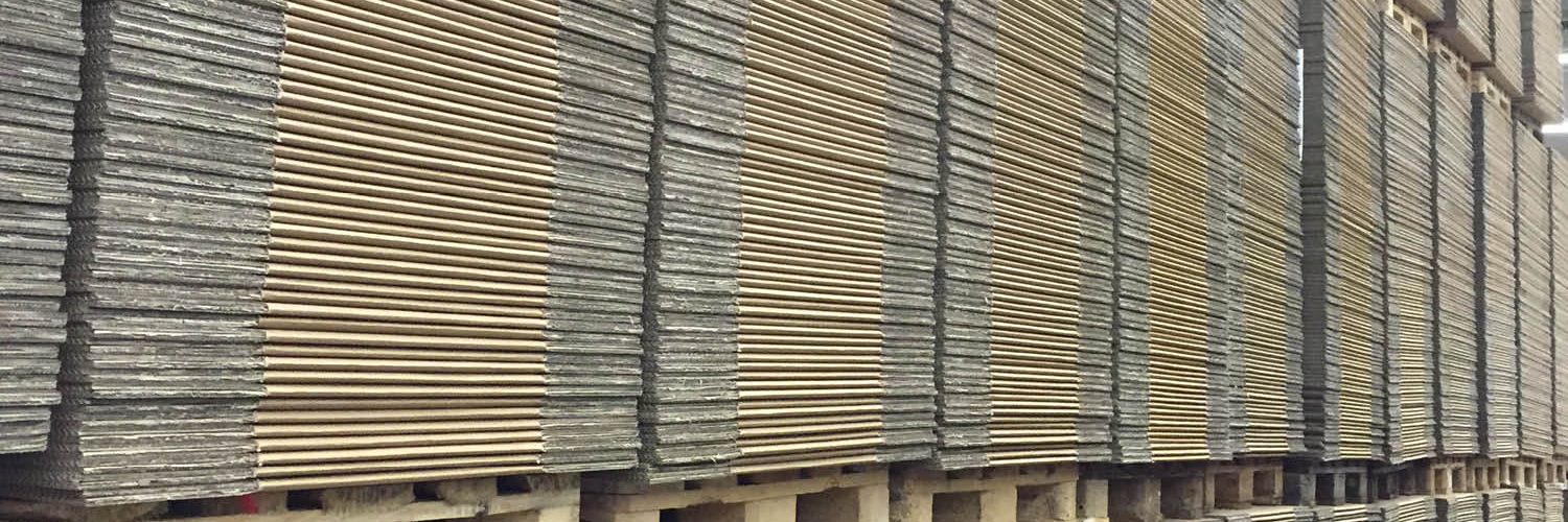 Ein Blick in unsere Lagerhalle: Gleichmäßig gestapelte Kartons auf Paletten, die eng aneinandergereiht sind und jederzeit auf Abruf für unsere Kunden bereitstehen.